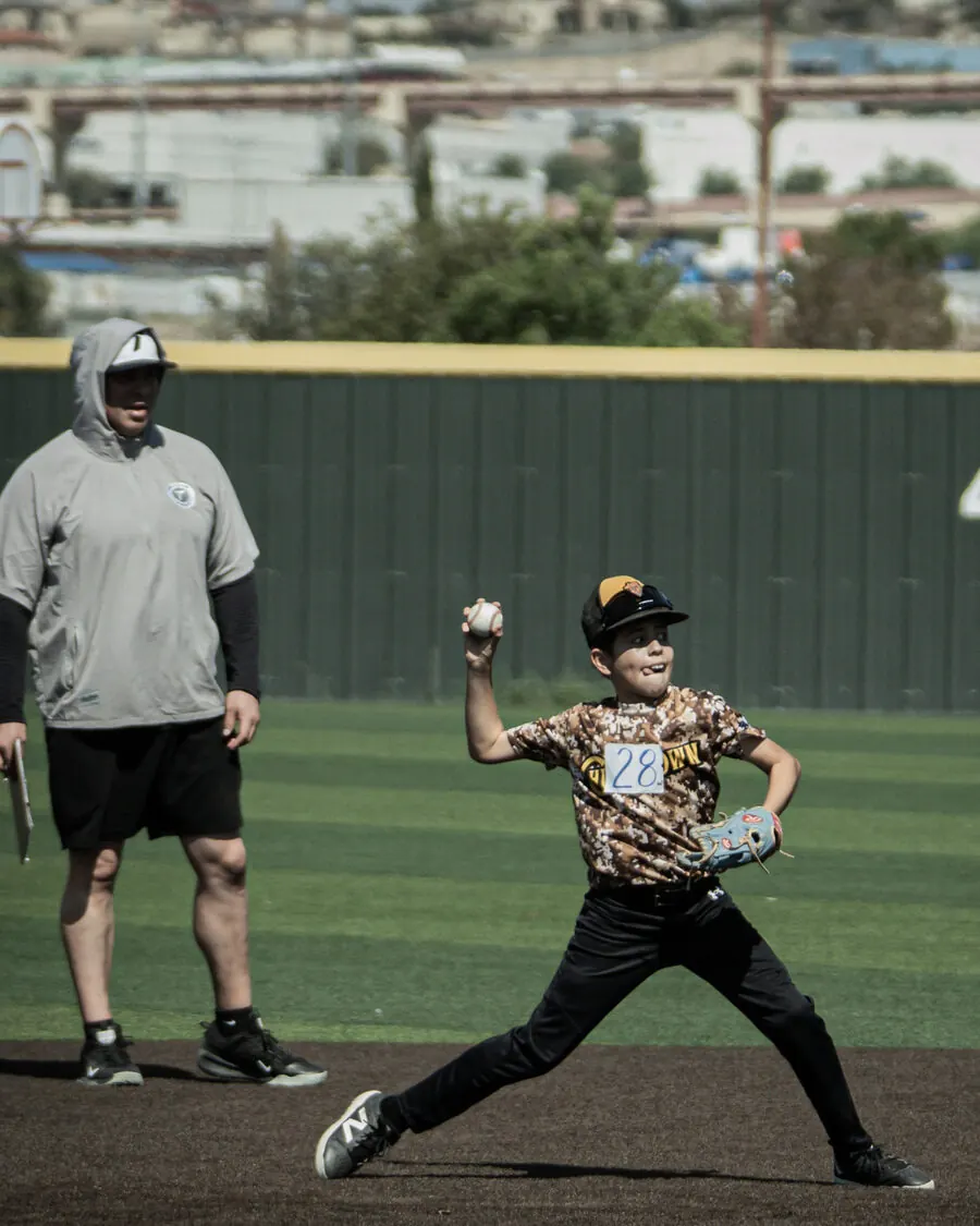 Young pitcher with a coach evaluating