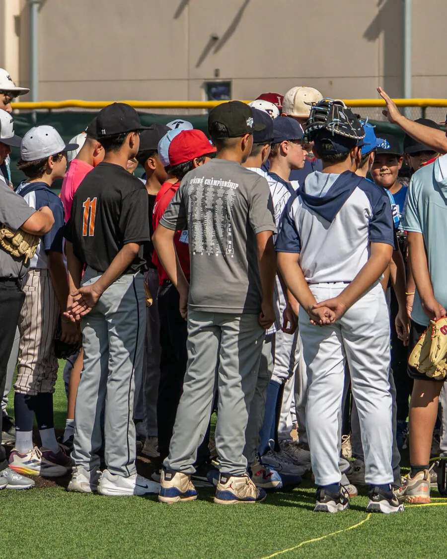Group of young TX Torque players listening to a coach on the field